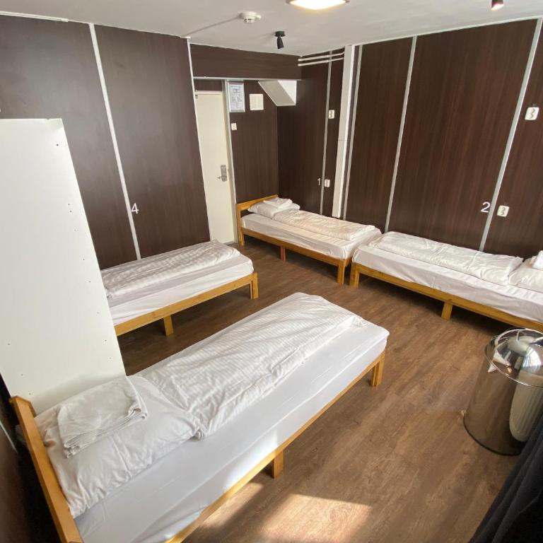 Dorm room with four single beds and wood-panelled walls