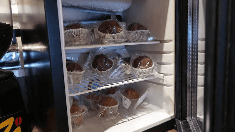 Fridge with shelves of individually wrapped muffins